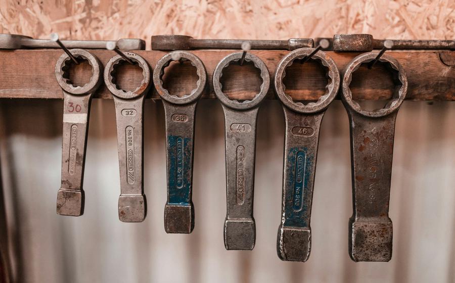 Set of heavy box-end wrenches hanging on a workshop wall